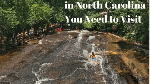 A person slides down the natural rock waterslide at Sliding Rock in North Carolina, with a crowd watching.