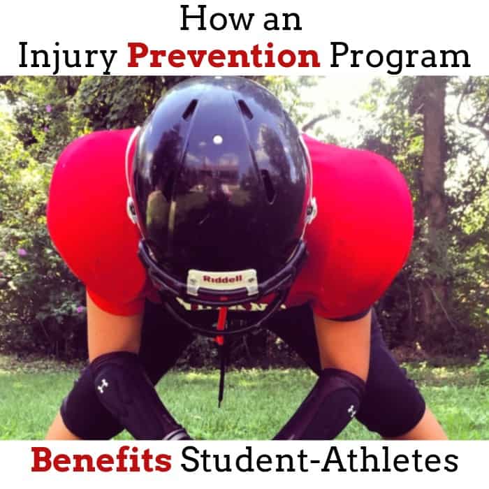 Football player in helmet and pads bends over on a grassy field.