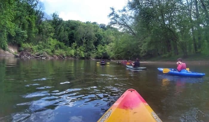 family kayaking on the river