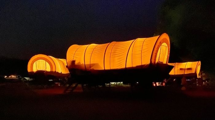 Covered wagons at night at Sheltowee Trace Adventure Resort in Kentucky