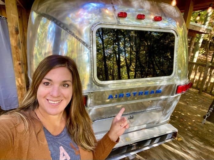 Nedra McDaniel outside The Silver Bullet Airstream Treehouse