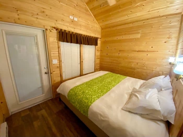 king size bed in bedroom of deluxe cabin at Flagstaff KOA Holiday