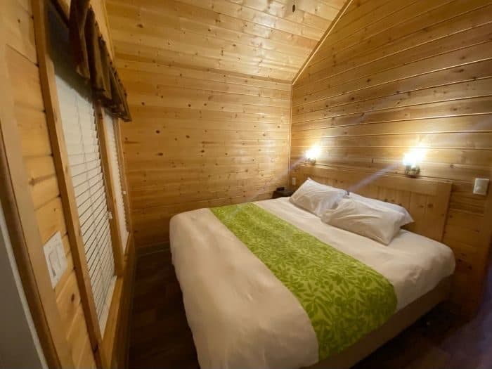 king size bed in bedroom of deluxe cabin at Flagstaff KOA Holiday