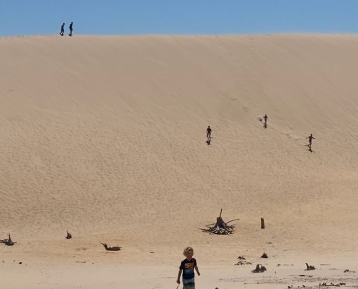 kids running down Silver Lake Sand Dunes e1626283736365