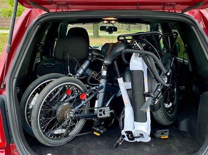 foldable Buzz electric bikes in the back of a SUV