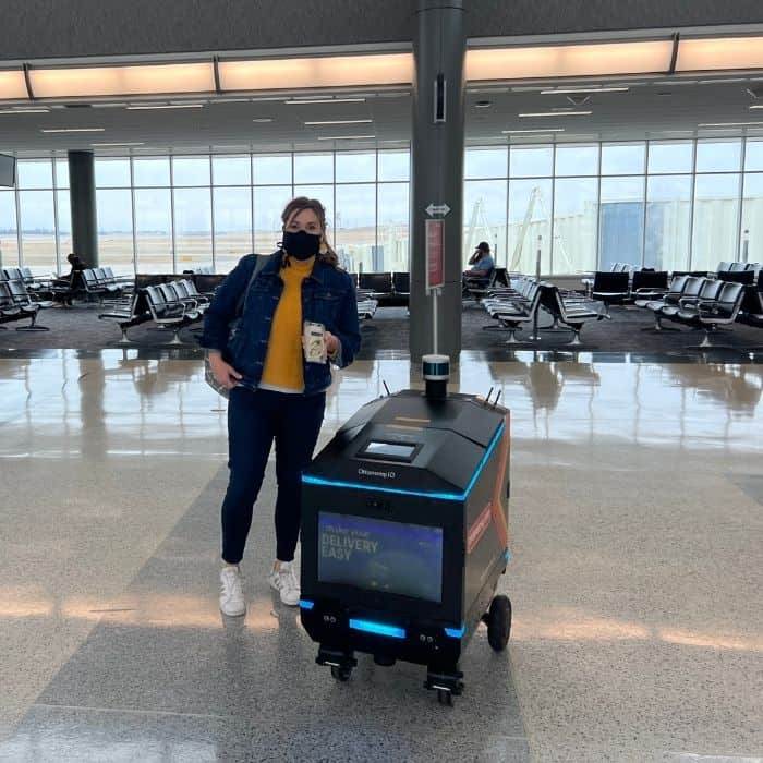 Nedra McDaniel with autonomous delivery robot at CVG Airport 