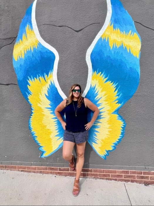Nedra McDaniel wearing Bionica athletic sandals in front of angel wing mural
