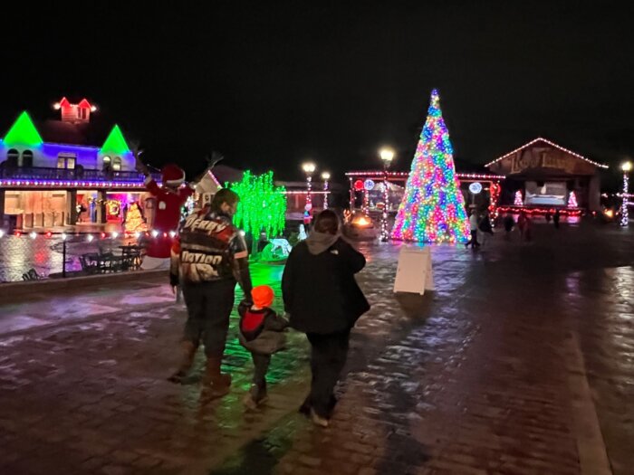 family walking around Christmas Village at Land of Illusion Christmas Glow