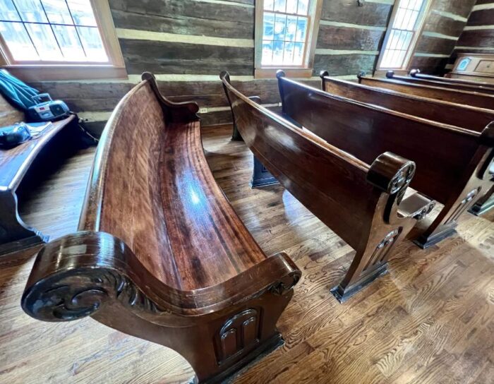 curved wooden pew inside the chapel at Heritage Farm 