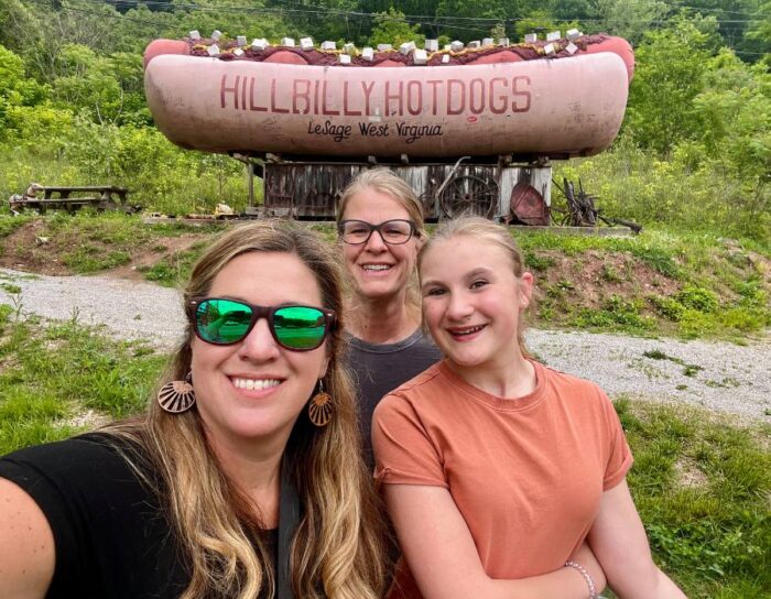 friends in front of Hillbilly Hot Dog Sign