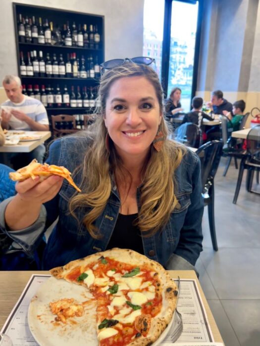 woman eating pizza in Naples Italy 