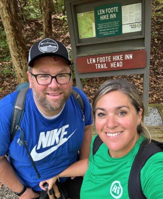 couple at sign for Len Foot Hike Inn trail head in Georgia
